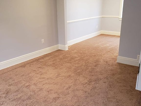 Living room, carpet throughout, recessed dimmable lighting.