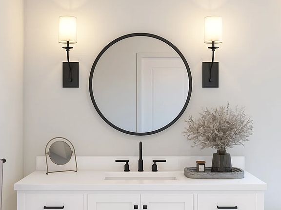 Primary bath with round mirror and sconce lighting