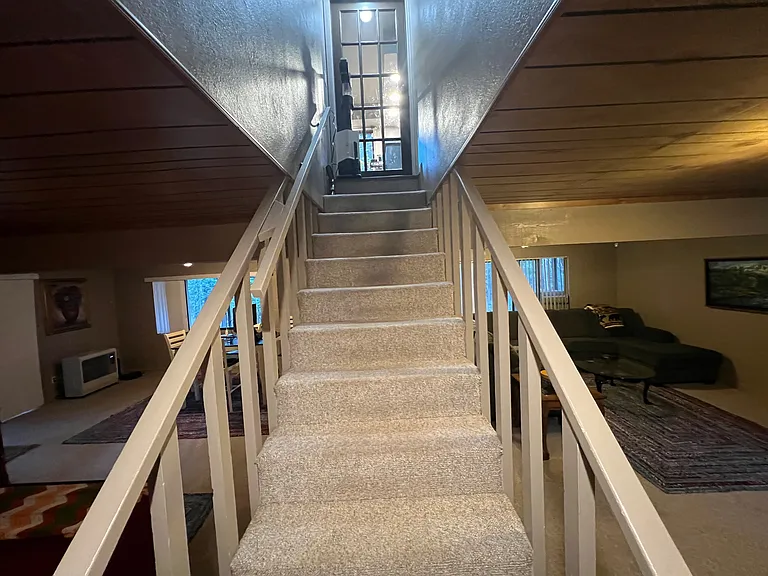 Stairs going down from Main Floor to Bottom 3rd Bedroom, w/entertainment center and space