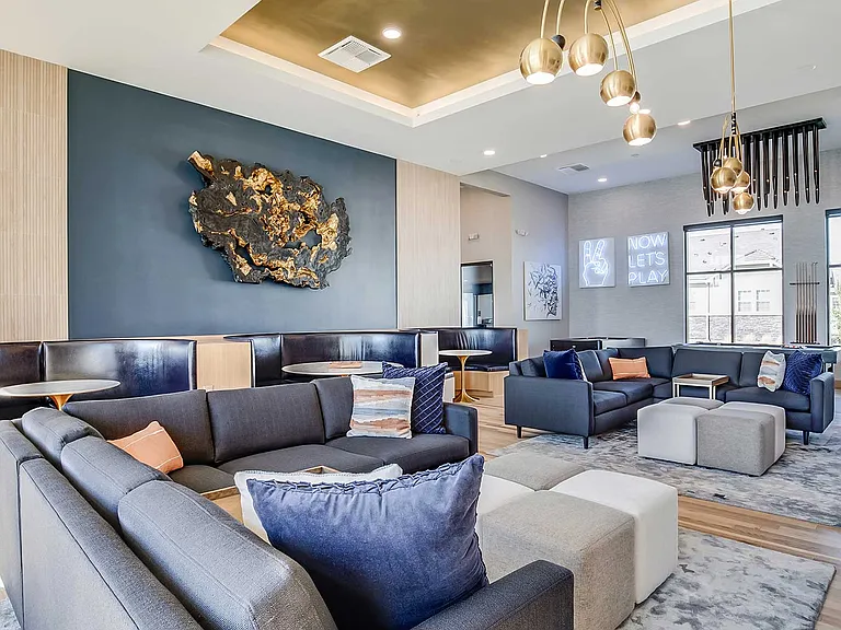 Gather, relax, or entertain in a beautifully designed resident clubhouse featuring plush seating, private booths, and a social game lounge atmosphere.