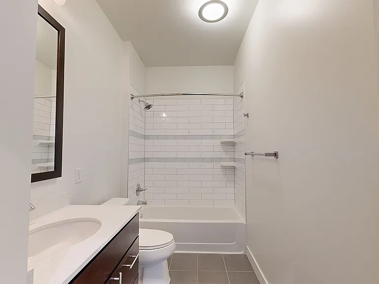 Apartment bathroom with wood-style flooring.