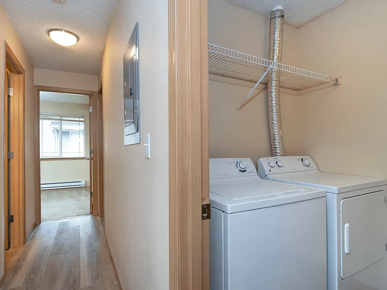 Convenience meets comfort! This hallway leads to a cozy bedroom and features an in-unit washer and dryer_making laundry day a breeze! #ApartmentLiving #ModernConvenience Convenience meets comfort! This hallway leads to a cozy bedroom and features an in-un