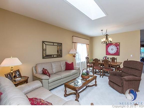 Open concept in living and dining rooms with skylight enhancing the space.