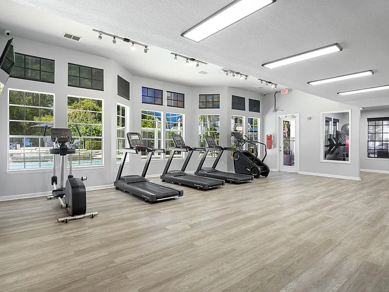 Cardio area with treadmills and a bike beside bright windows to start mornings strong