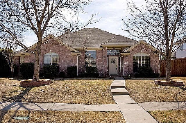 Front has two large trees.