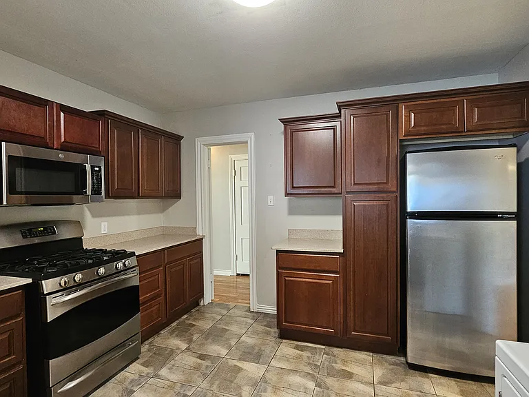 Kitchen, comes with a gas range, microwave, refrigerator, and plenty of cabinet space.