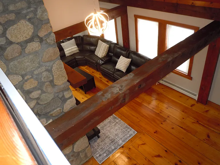 Large living room with vaulted ceilings and wood detailing throughout.