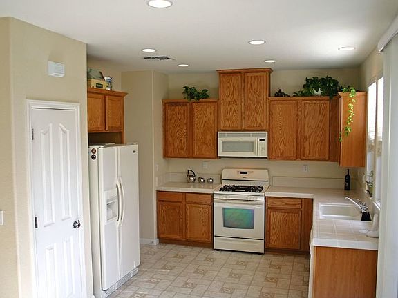 Open kitchen has upgraded appliances, pantry