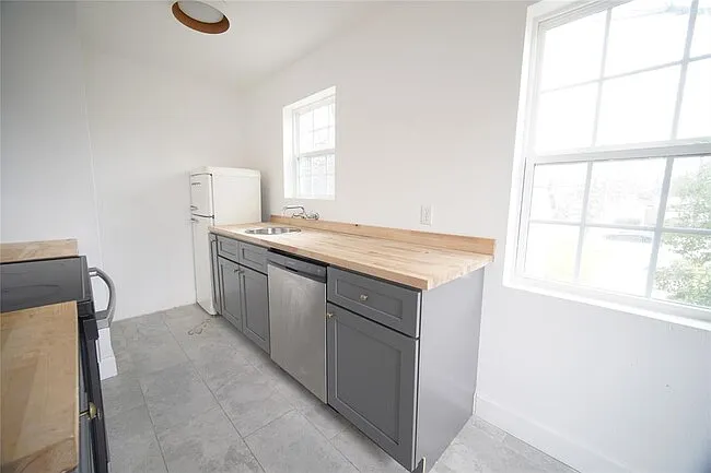 Full kitchen with stove, vent, dishwasher and fridge