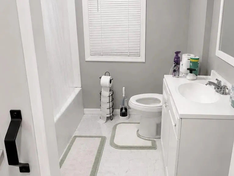 Full bathroom with tub/shower combo, single-sink vanity, and window with blinds for ventilation and natural light.