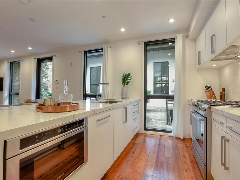 The condo features bookmatched Calacatta quartz countertops and a gas stove.