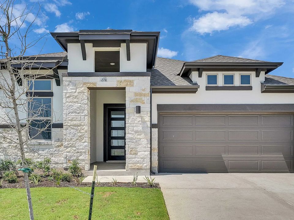 Revel in this exquisite modern home with elegant stone facade and lush greenery in Lakeside Meadows.