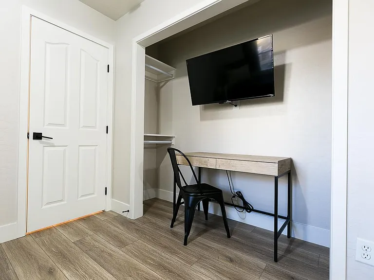 A workstation in the downstairs bedroom with an in bedroom tv