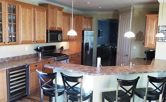 Lovely kitchen with upgraded cabinets, stainless upscale appliances, dual level breakfast bar & even a wine cooler!