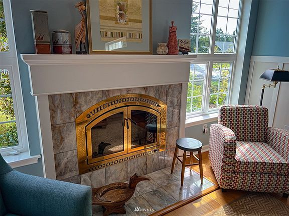 Marble surround wood burning fireplace anchors the spacious living room.>
