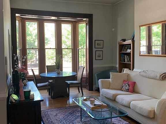 Living/ dining area. 5 brand new windows and trim. Furniture included- sofa, glass coffee table, cabinet, dining room table and 4 chairs and rug.