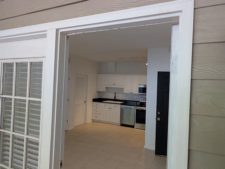 The screened porch looks through the living room into the open kitchen