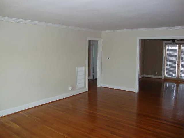 Living room view of "3rd" bedroom/den on right and hallway entrance to bath and bedrooms on left.