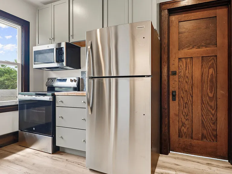THisis a shot of a well apponted kitchen and that is the back door leading to the stairway and side entrance. THERE IS ALSO A PORCH off the back!