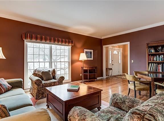 Spacious living room with crown molding and great natural light from front window