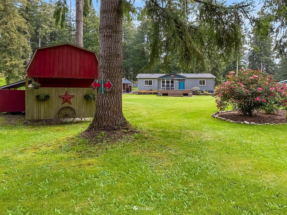 Looking for that peaceful and private setting, little bit of country and a close to city, this one is for you.  New Shop, never used, additional two car garage with smaller shop in back of it.   Circular drive way, two RV hook ups - one full and another one in new shop.  1.26 acres allows you to stretch out and enjoy the beauty of serenity.  From the street a view of the small barn, with covered addition on side and covered extension off front.  Wagon wheel and decor on front of barn do not stay with sale of home