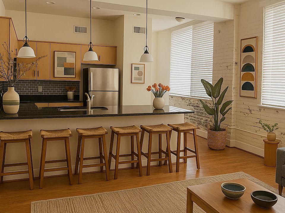 Walk in to an open concept living room and kitchen area. The kitchen includes full sized stainless steel appliances, granite countertops, and solid wood cabinets. The windows provide ample light in the condo and make for a relaxing and open atmosphere.