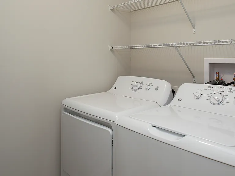 Laundry room with chalkboard wall and storage space in select units