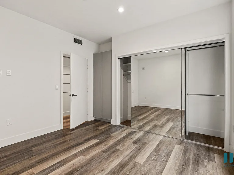 Bedroom with Mirrored Closet, Vinyl Flooring, and Recessed Lighting