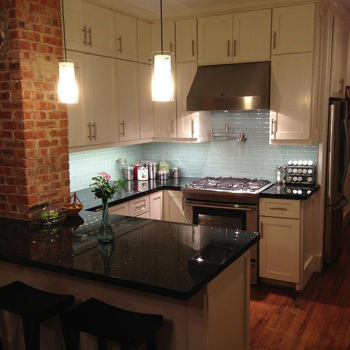Kitchen island, glass tiles, lots of cabinets and lighting, gas stove, original chimney