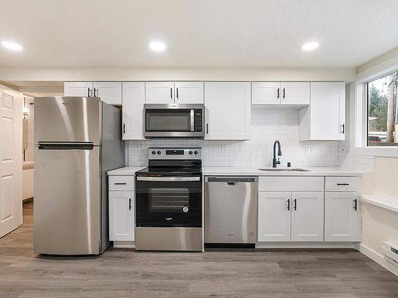 Full size Whirlpool appliances: fridge with built-in icemaker, oven, 4 burner range, microwave that vents outside, dishwasher, and garbage disposal.