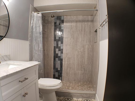 Step into luxury with our newly remodeled tile shower, featuring a mesmerizing water wall effect that elevates your bathing experience to new heights.