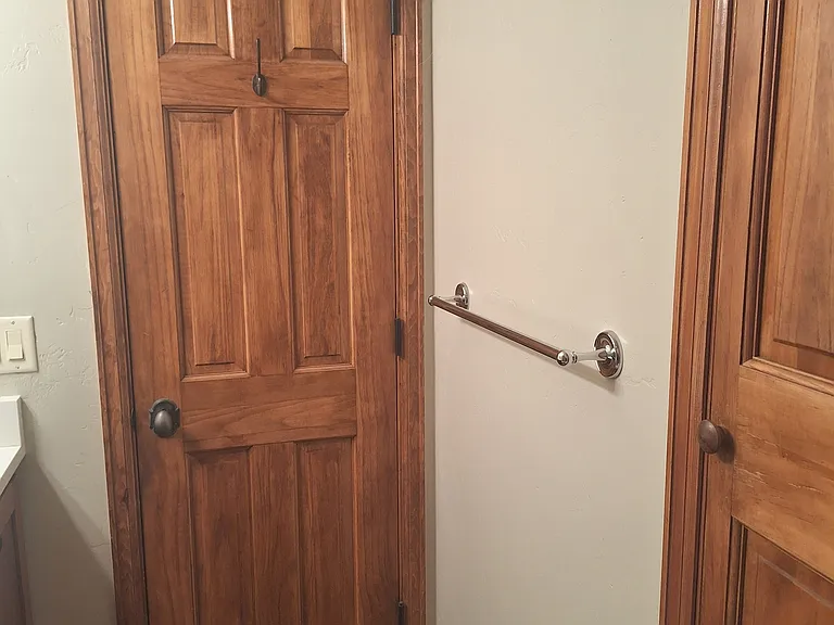Middle bathroom with two bath towel racks and storage closet.