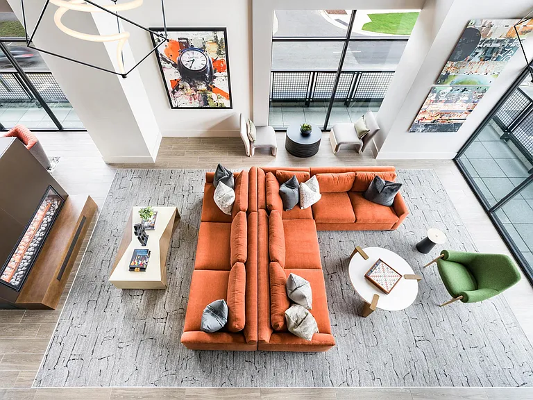 Expansive resident lounge with floor-to-ceiling windows, bold design, and inviting spaces to gather.