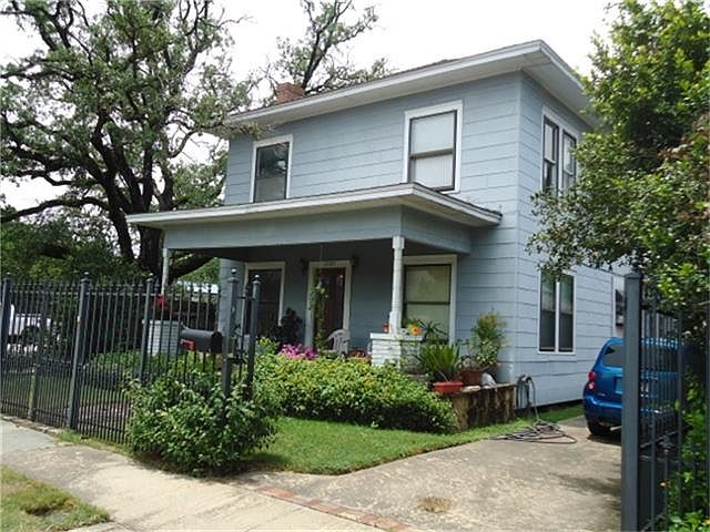 Splendid corner lot 2 story home surrounded by wrought iron fencing and large majestic oak tree.