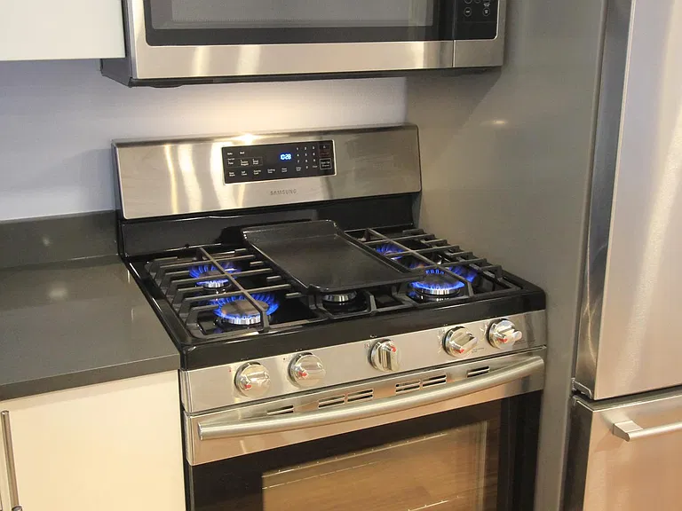 Gas range with externally vented microwave
