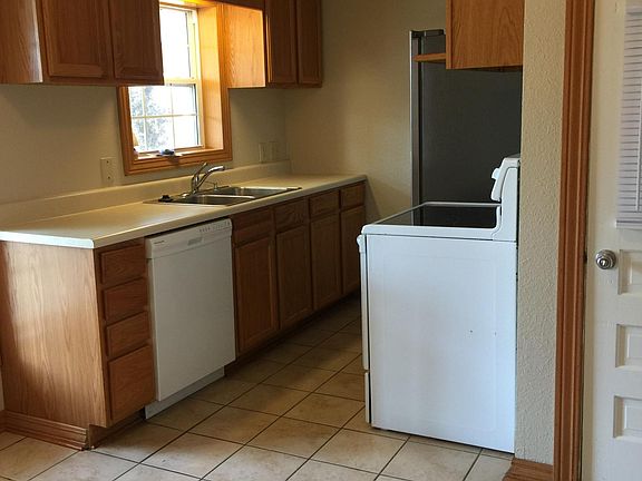 Eat-in kitchen with dishwasher, flat-top stove and side-by-side refrigerator with ice maker.