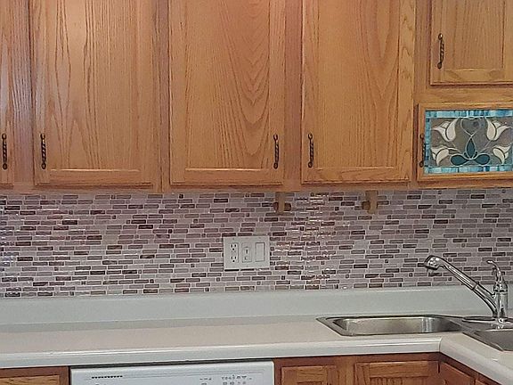 Kitchen includes dishwasher, double sink, refrigerator, brand new gas stove and oven. Features internally lit wine glass cabinet with beautiful stained glass.