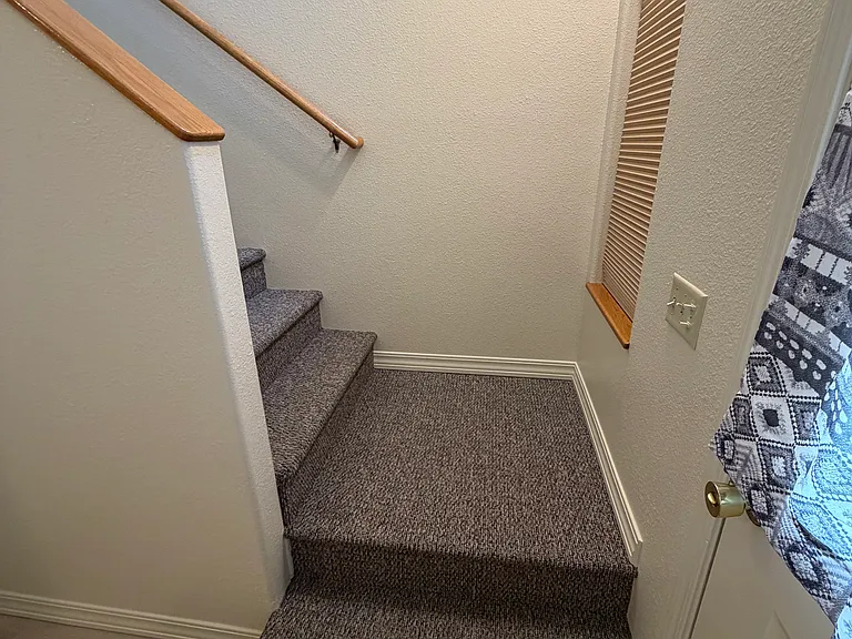 Stairs leading from the front door to the three upstairs bedrooms.