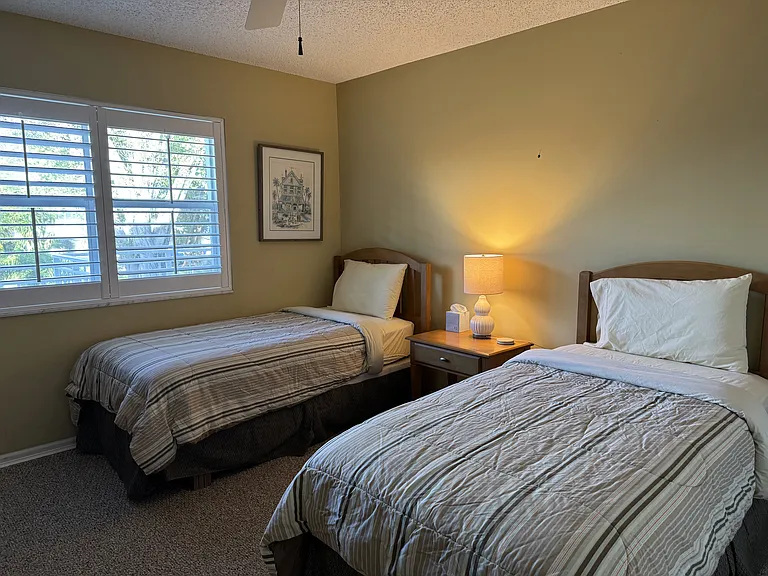 Guest bedroom with twin beds and flat screen tv.