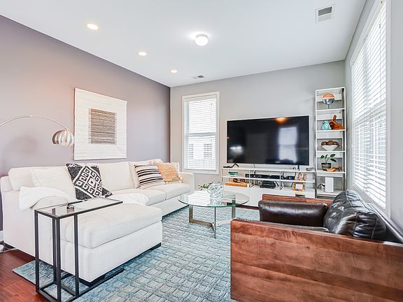 Come into a bright living room with modern paint and recessed lighting.