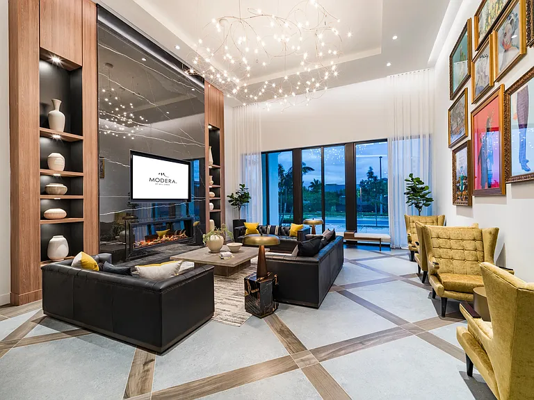 A social lounge at Modera Aventura, where sculptural lighting, curated art, and indoor-outdoor views reflect the energy and style of South Florida living.