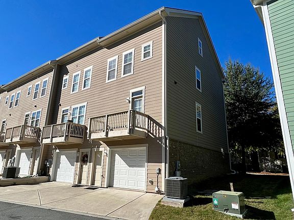 End unit with brick / hardboard siding. One car finished garage and outdoor terrace.