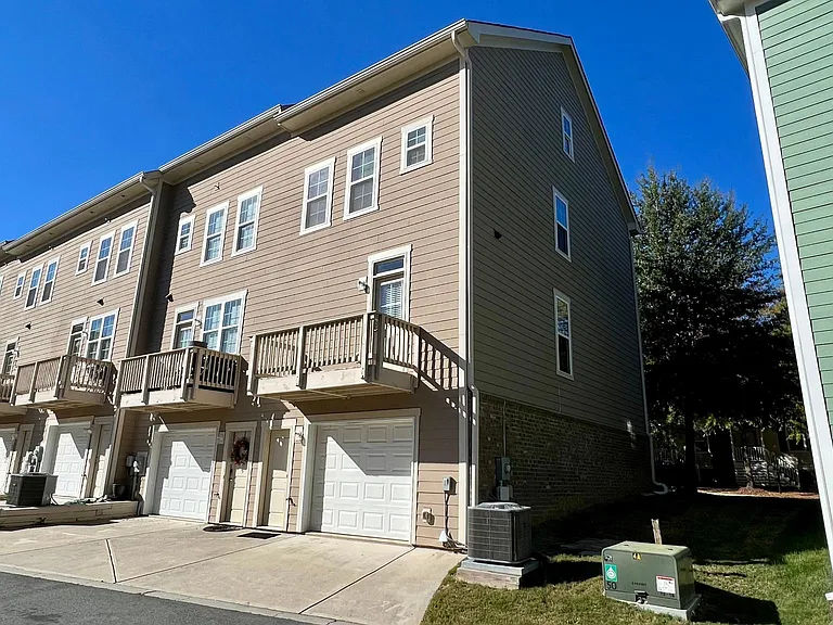End unit with brick / hardboard siding. One car finished garage and outdoor terrace.
