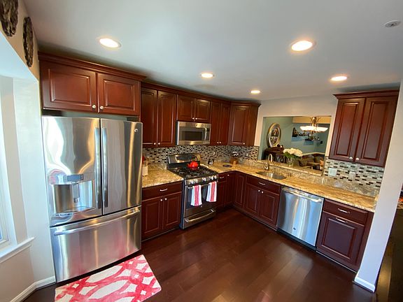 Custom kitchen with cherry cabinets, granite countertops, stainless steel gas appliances, dining room pass through, and ample natural light.