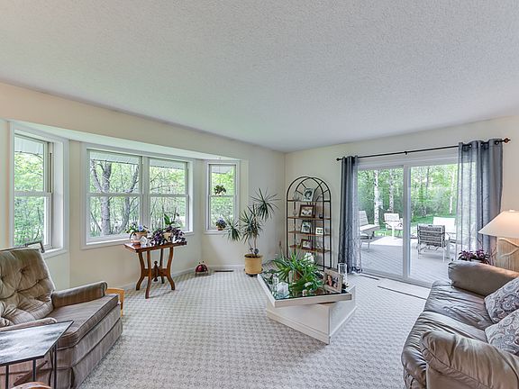 The living room with bay window and glass sliders to the deck offer wonderful natural views to bring the outside in.