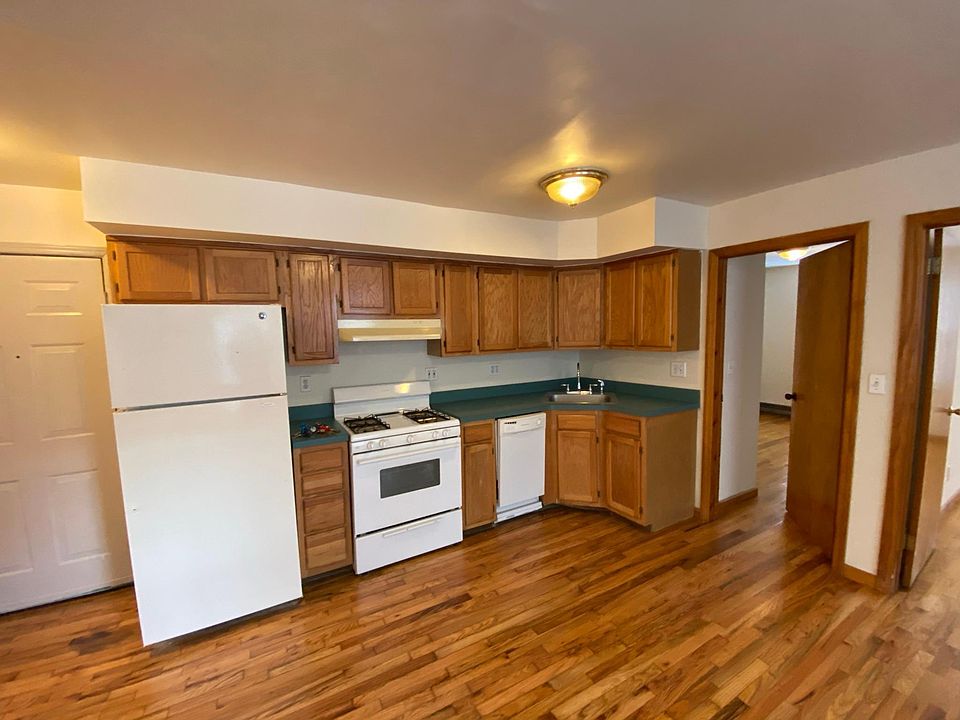 Open kitchen with gas range, dishwasher, & fridge