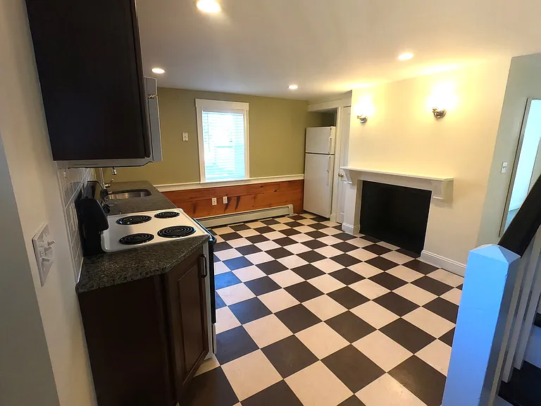 Eat in, retro-vibe kitchen with decorative fireplace and barn board wainscoting.