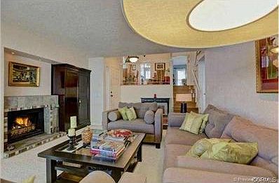 Gas fireplace with tile surround and recessed lighting.