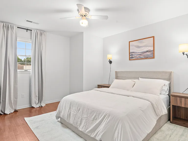 Comfortable upper-level bedroom with a queen bed, dresser, ceiling fan, and closet storage.