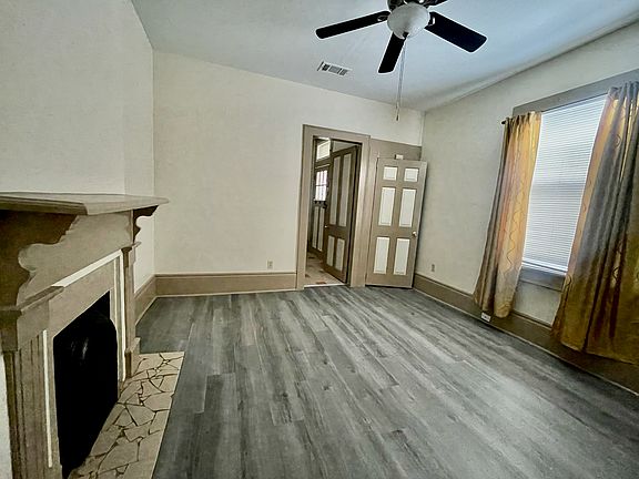 Bedroom adjacent to kitchen has a ceiling fan.